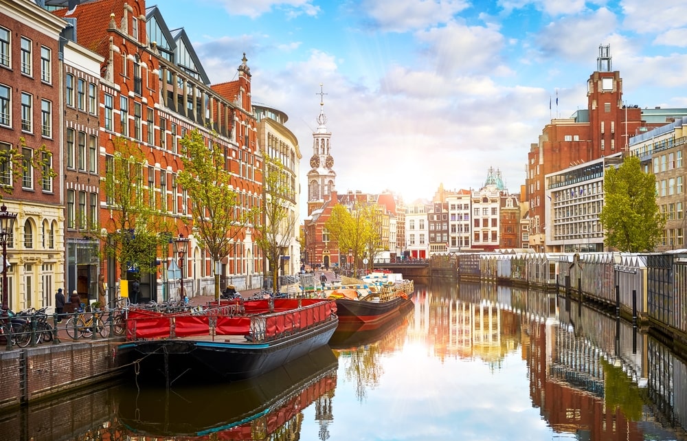 Gracht in Amsterdam, Nederland. Huizen en rivier de Amstel. Bekend Europees herkenningspunt. Oud stadslandschap tijdens zonsondergang.